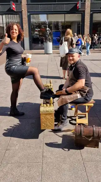 A seated guest enjoying a shoeshine in the city.