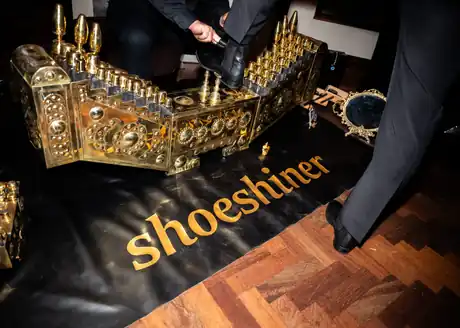 The brass shoeshine box, brushes and care products during a shoeshine.