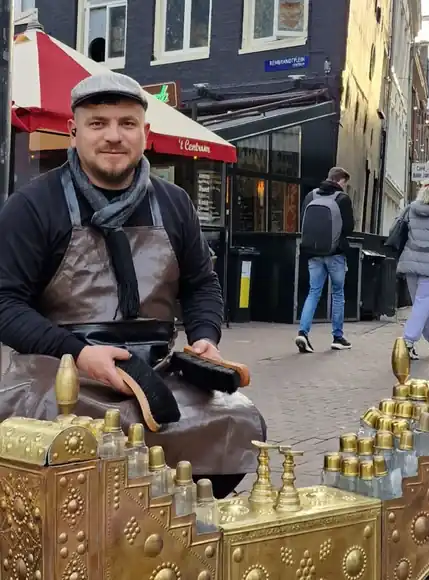 Shoeshiner with brushes and the brass shoeshine box.
